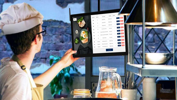 Chef che utilizza un menu digitale su touchscreen per gestire gli ordini del ristorante